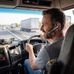 Dual-mic wireless Bluetooth noise cancelling headset worn by a truck driver